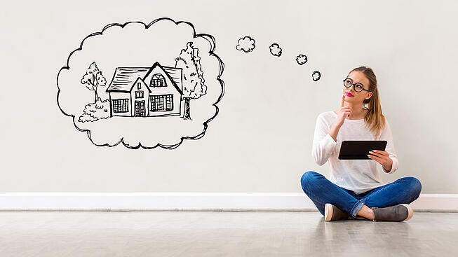 Beleihung in welcher Höhe Frau schaut in eine Wolke in dem ein Haus mit Fragezeichen abgebildet ist.